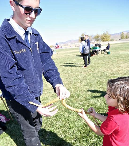 Carson Valley FFA member Steven Rodgers holds a corn snake for Noah Bosch to touch Friday at Fremont Elementary.