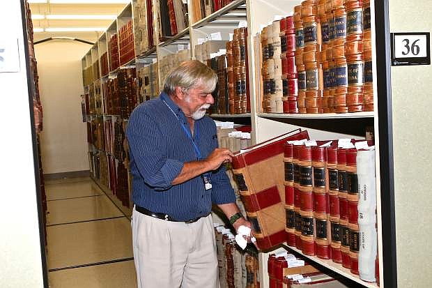 Nevada State Archivist Jeff Kintop pulls a giant book full of handwritten legislative notes from its slot in the basement of the archives Thursday morning in Carson City.