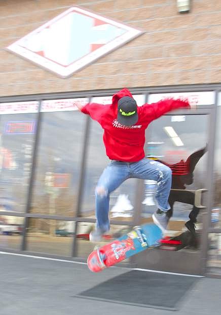 Matt Bartak, Founder and CEO of The Wheelhouse, does a kick-flip on his skateboard in front of the store on Rhodes St. in Carson City Thursday.