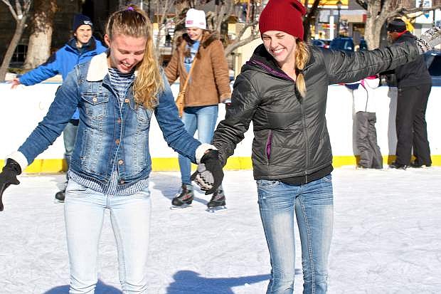 Brazilian exchange student Janice Lotterman (left) gets help from Elizabeth Everest Saturday afternoon at the Arlington Square ice skating rink. It was Lotterman&#039;s first time on the ice.