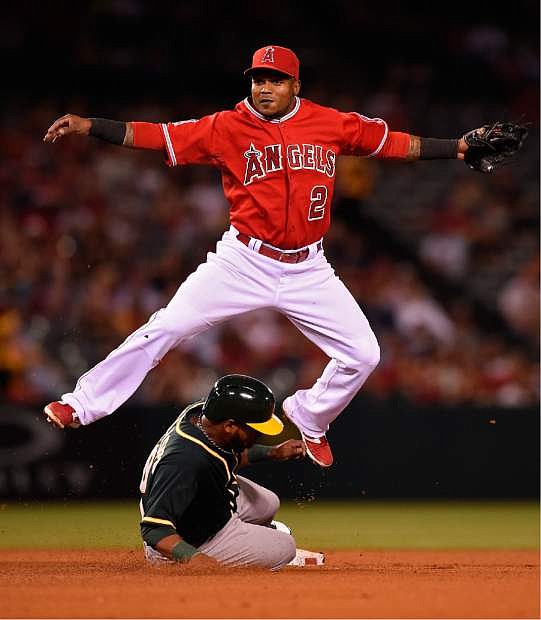 Oakland Athletics&#039; Alberto Callaspo, below, is forced out at send as Los Angeles Angels shortstop Erick Aybar throws out Nick Punto at first to complete the doubleplay during the fifth inning of the MLB American League baseball game, Monday, April 14, 2014, in Anaheim.  (AP Photo/Mark J. Terrill)