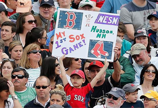 A young fan holds a sign in the fifth inning of a baseball game between the Boston Red Sox and the Oakland Athletics in Boston, Saturday, May 3, 2014. (AP Photo/Michael Dwyer)