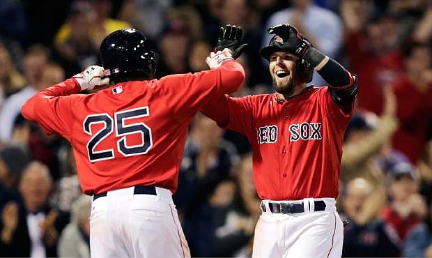Boston Red Sox&#039;s Dustin Pedroia is congratulated by teammate Jackie Bradley Jr. (25) after his grand slam off Oakland Athletics relief pitcher Ryan Cook during the sixth inning of a baseball game at Fenway Park in Boston, Friday, May 2, 2014. (AP Photo/Charles Krupa)