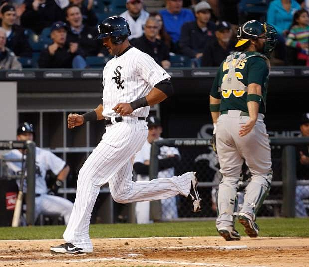 Chicago White Sox&#039;s Alex Rios, left, scores past Oakland Athletics catcher Derek Norris on a sacrifice fly by Dayan Viciedo during the fourth inning of a baseball game on Friday, June 7, 2013, in Chicago. (AP Photo/Charles Rex Arbogast)