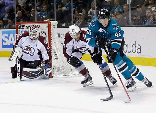 San Jose Sharks&#039; Tomas Hertl, right, of the Czech Republic, is defended by Colorado Avalanche&#039;s Marc-Andre Cliche (24) as goalie Jean-Sebastien Giguere, left, watches during the first period of an NHL hockey game on Friday, April 11, 2014, in San Jose, Calif. (AP Photo/Marcio Jose Sanchez)