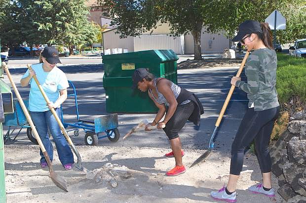 Kayla Curnel, Kenyatta Hines and Elie Mataafa of CVW-3 try to remove a stump at the Brewery Arts Center Saturday morning.