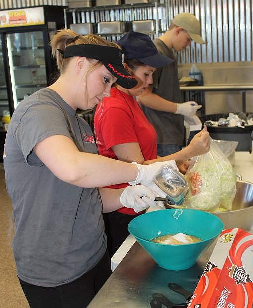 From left, Melissa Thompson, Angel Fermaint and Hunter Doyle prepare lunch at the Big Boys BBQ.