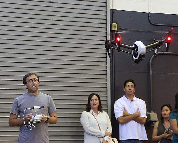 University of Nevada, Reno assistant professor Richard Kelley, also chief engineer and researcher for the Nevada Advanced Autonomous Systems Innovation Center, demonstrates for a group of visitors a new quadcopter being used to locate hazardous waste at an EPA clean-up site.