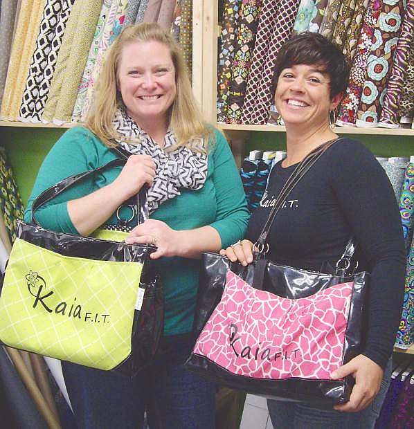 Karen Scott of Too Cute Totes, left, and Andrea Schell of Kaia FIT pose with two of the Kaia Queen athletic bags crafted by Scott. The two business owners have partnered up to offer free Kaia FIT sessions for one Fallon and one Fernley woman.