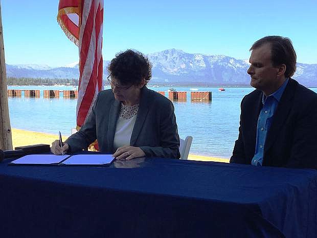 U.S. Department of Interior Assistant Secretary for Lands and Minerals Management Janice Schneider (left) signs the $30 million wildfire prevention projects with USDA Under Secretary for Natural Resources and Environment Robert Bonnie (right).