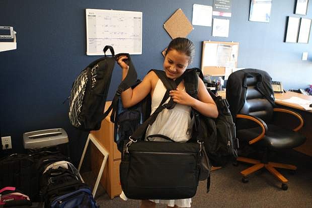 Eleven-year-old Laurel Czujko carries a bunch of backpacks filled with school supplies on Thursday. Almost 300 backpacks were filled with school supplies and hygiene items on Thursday at the Navy recruiting station for Carson City students. The backpacks will go to all schools in the Carson City School District as well as Capital City Circles and Child Protective Services. Soroptimist International of Carson City and Platinum Plus Salon &amp; Spa sponsor the annual fundraiser.