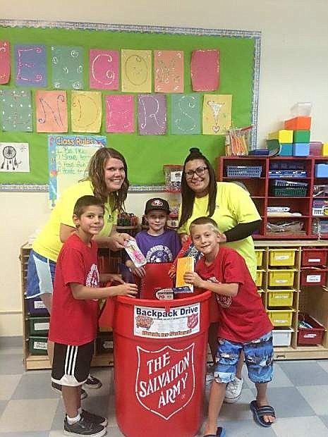 From the left, Cruz Gonzales, Recreation Lead Lindsey McElfish, first grader Rhyker Ricks, Recreation Aide Supervisor Sierra Fowzer, and second grader Chase Gonzales add school supplies to a Salvation Army donation bin.