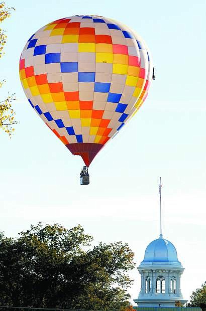 Published Caption: Right: A hot air balloon floats past the state Capitol building on Saturday morning.