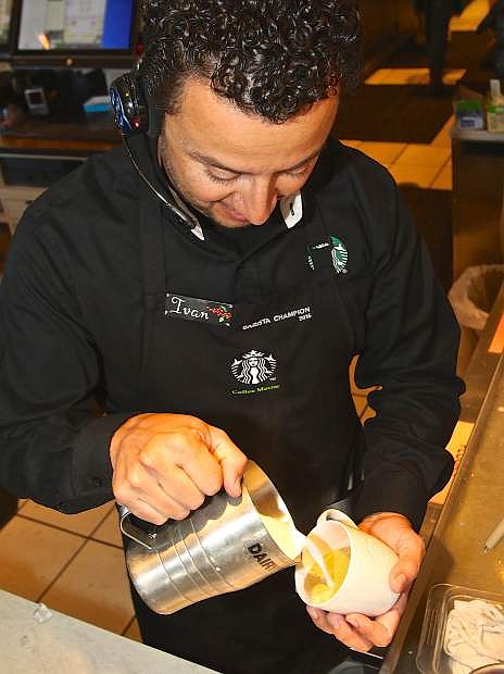 Ivan Rizo-Pineda pours milk into a flat white latte Wednesday at the north Starbucks in Carson City.