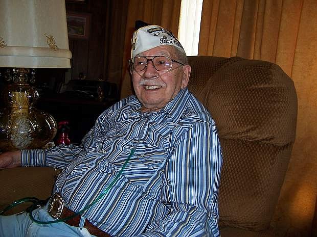 Roland relaxing in his chair sharing Pearl Harbor stories. He proudly wore his Pearl Harbor survivor hat with his famous smile.