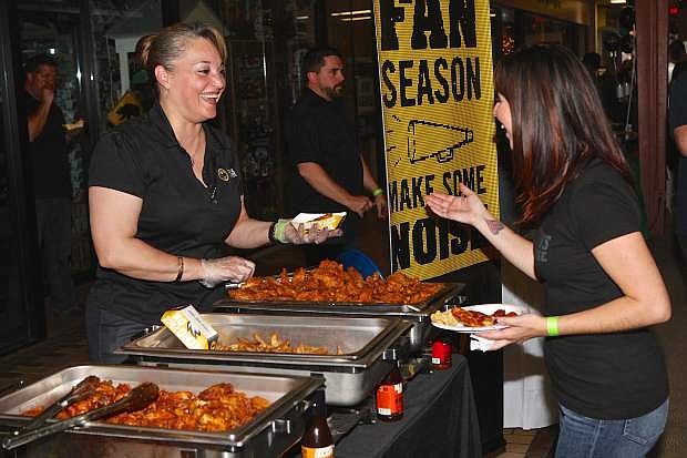 Buffalo Wild Wings General Manager Tamika Rodriguez serves 2 Towns Ciderhouse&#039;s Nicole Martin chicken wings Saturday at the Carson City Rotary Club&#039;s Beer and Pizza Championships at the Carson Mall.