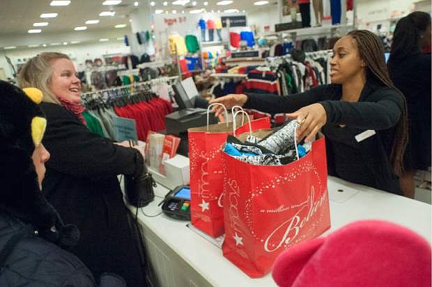 This Nov. 28, 2013 photo released by Macy&#039;s shows Wendy Landry, left, purchasing items from sales associate Ashley Smith at the Macy&#039;s Lenox Black Friday store opening in Atlanta. In the pre-dawn hours Friday, as some early-rising shoppers were heading into malls in search of Black Friday deals, others had been up shopping all night in stores that opened the evening of Thanksgiving or at 12:01 a.m. Friday. (AP Photo/Macy&#039;s, Paul Abell)