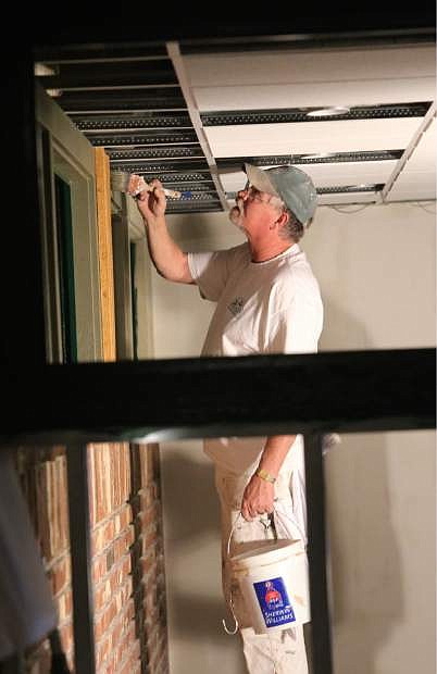 Ron McCain paints trim work on Monday in the new Black Bear Diner being built inside Max Casino.