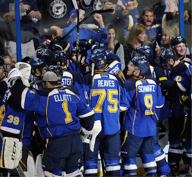 St. Louis Blues surround teammate Barret Jackman, center, after his game-winning goal against the Chicago Blackhawks during overtime in Game 2 of a first-round NHL hockey playoff series, Saturday, April 19, 2014, in St. Louis. (AP Photo/Bill Boyce)