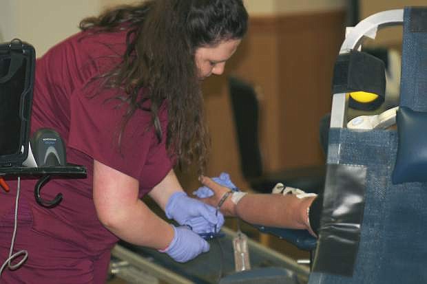 A phlebolomist prepares the equipment to begin taking a patron&#039;s blood at the Battle of the Badge blood drive Tuesday in Carson City.