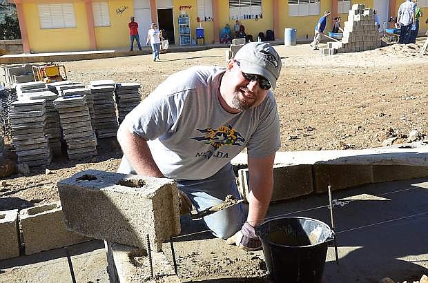 Keith Boone applies cement for a brick wall he was building at the vocational school in Constanza, Dominican Republic.