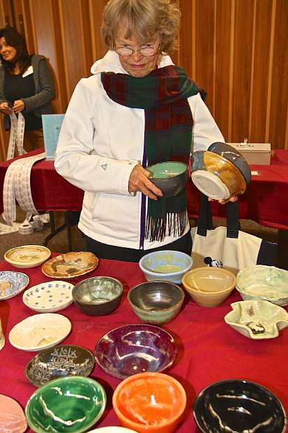 Carol Wilson of Carson City previews the bowls available for purchase Thursday night at the First Presbyterian Church.