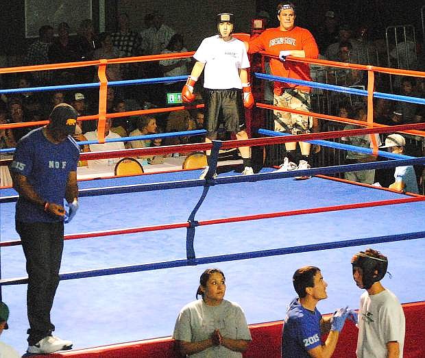 Coach Mitch Overlie, bottom right, applies vaseline to the face of Davis Koenig before Koenig&#039;s bout against Jaime Gonzales on Friday at the Night of Boxing.
