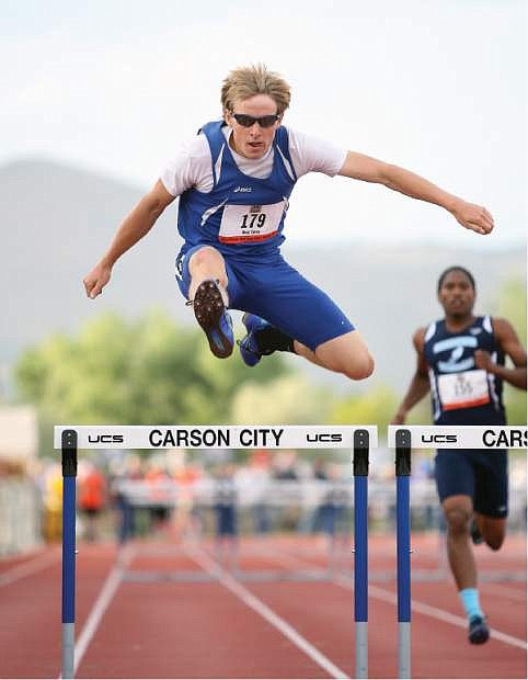 CHS Junior Cory Reid punches over the last hurdle in the boys 300 Friday evening.