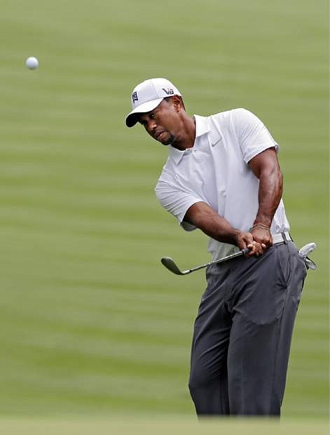 Tiger Woods chips to the 13th green during practice for the Bridgestone Invitational golf tournament Wednesday, July 31, 2013 at Firestone Country Club in Akron, Ohio. (AP Photo/Mark Duncan)