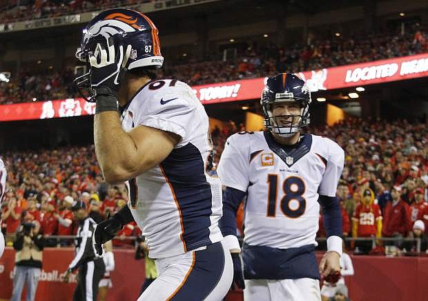 Denver Broncos quarterback Peyton Manning (18) congratulates wide receiver Eric Decker (87) for a touchdown reception during the second half of an NFL football game against the Kansas City Chiefs, Sunday, Dec. 1, 2013, in Kansas City, Mo. (AP Photo/Ed Zurga)