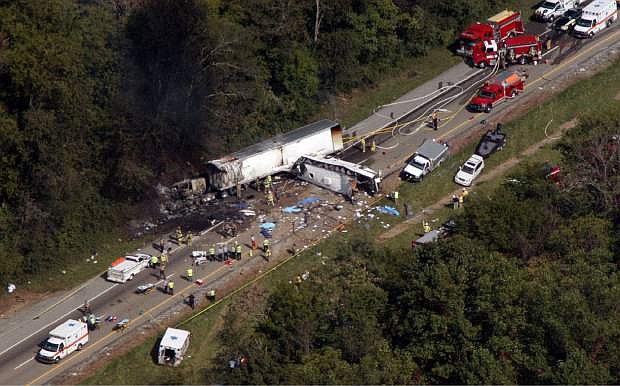 In this aerial photo, emergency workers respond to a crash involving a church bus and a tractor-trailer near Dandridge, Tenn., on Wednesday, Oct. 2, 2013.  Authorities say a tire on the bus blew out and the bus hit the tractor-trailer and a sport utility vehicle, killing eight people. (AP Photo/Citizen Tribune, Gary Smith)