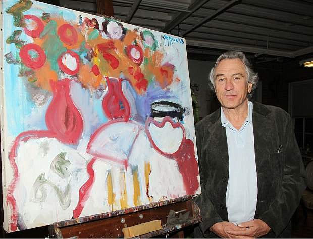 FILE - In this Wednesday, Nov. 17, 2010 file photo released by Starpix, actor Robert De Niro stands next to a painting executed by his father, Robert De Niro Sr., in New York. De Niro has made a documentary about his father, abstract expressionist painter Robert De Niro Sr., called &quot;Remembering the Artist Robert De Niro Sr,&quot; which premiered at Sundance Film Festival and will air on HBO in June 2014.(AP Photo/Starpix, Dave Allocca, File)