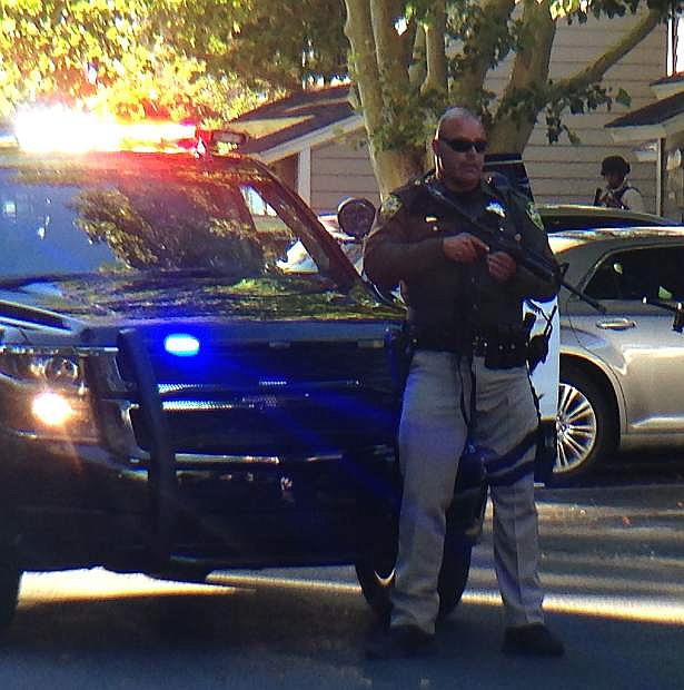 A Carson City deputy stands guard during a search warrant execution Sunday evening. Authorities were searching for evidence in relation to a gang-related murder in Yuba City, Calif. several weeks ago.