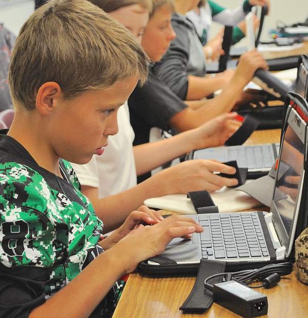 Churchill County Middle School student Martin Towne cracks open his Google Chromebook for the first time.