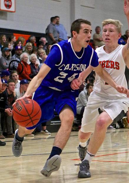 Senator point guard Jared Rooker drives past Douglas&#039; Dylan Pfaffenberger Friday night in a win against the Tigers in Minden.