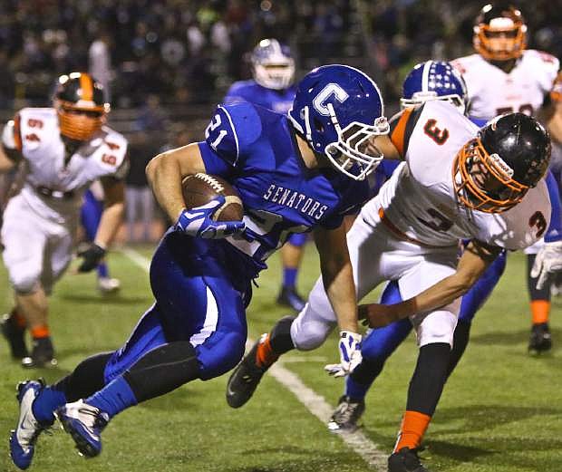 Carson running back Colby Brown goes around the right corner and is brought down by Douglas&#039; Sam Melhus Friday night at Carson High.