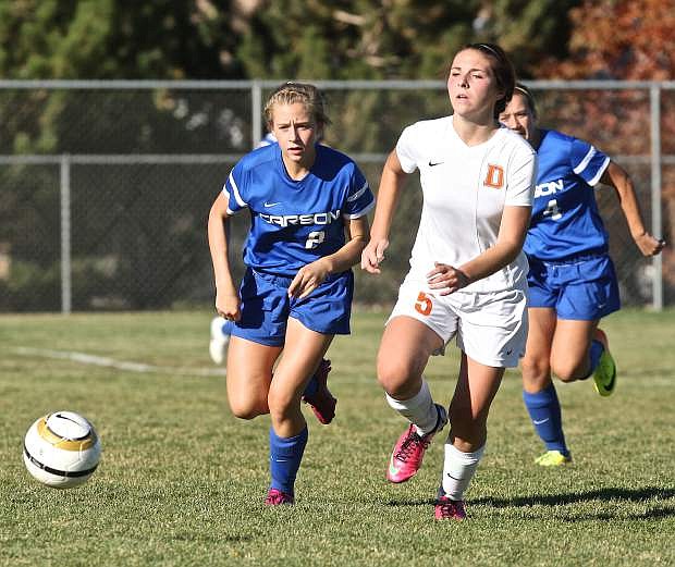Carson&#039;s Lauren Hudak pushes the ball downfield against Douglas&#039; Caitlyn Bidart on Friday at Douglas High. The Tigers won the game 2-1.