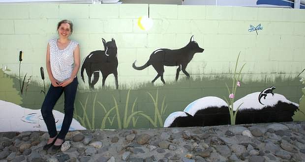 Carson High School senior Erica Gallegos leans against a mural she painted on a cinder block wall by the Fulstone Wetlands park.