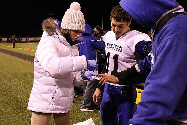 Carson High School football manager Caroline Gabica tends to Sevon Mandoki on the sidelines of the Carson-Reed playoff game in November. Gabica is a second year student in the Carson High School Career and Technical Education sports medicine program.