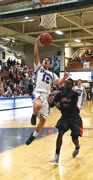 Senior Kyle Steele (15) is fouled on the way to the bucket by Douglas&#039; Sam Broersma Friday night. The Senators won the Sierra league game 37-29.