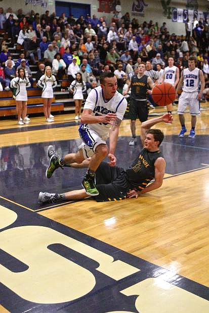 Carson senior Cameron Price gets fouled by Manogue&#039;s Justin De Geus in a double-overtime win for the Senators Thursday night.