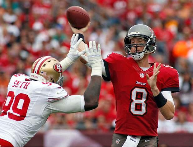 Tampa Bay Buccaneers quarterback Mike Glennon (8) fires the football as he is about to be hit by San Francisco 49ers outside linebacker Aldon Smith (99) during the third quarter of an NFL football game Sunday, Dec. 15, 2013, in Tampa, Fla. (AP Photo/Reinhold Matay)