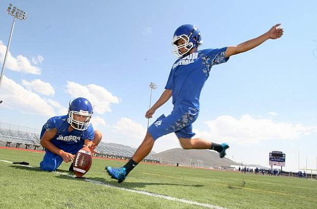 Punter Brandon Gagnon sets the football for place kicker Jonny Barahona during afternoon practice.