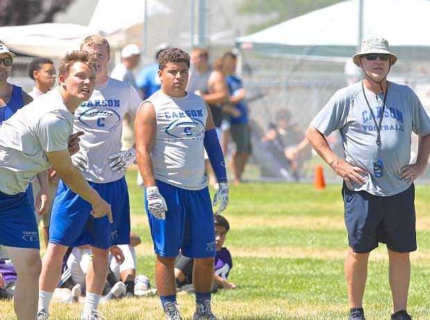 Coach Blair Roman (right) watches quarterback Jace Keema throw to a receiver during the Flying Tigers 7-on-7 tournament at Douglas High Friday.