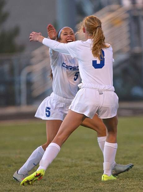 Isabella Wakeling (5) celebrates with Mallory Otto after Carson took an early 1-0 leady against Douglas in regional tournament play Saturday at North Valleys High School. Douglas went on to win the game 3-1.