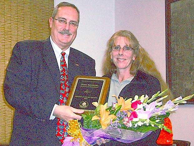 Mayor Ken Tedford Jr.congratulates Doni Kowalski, right, with a plaque and flowers for Employee of the Quarter.