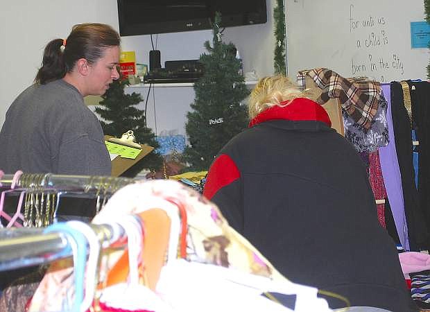 Shannon Stewart, a church volunteer, helps a woman with clothes at Saturday&#039;s Gifts for Giving.
