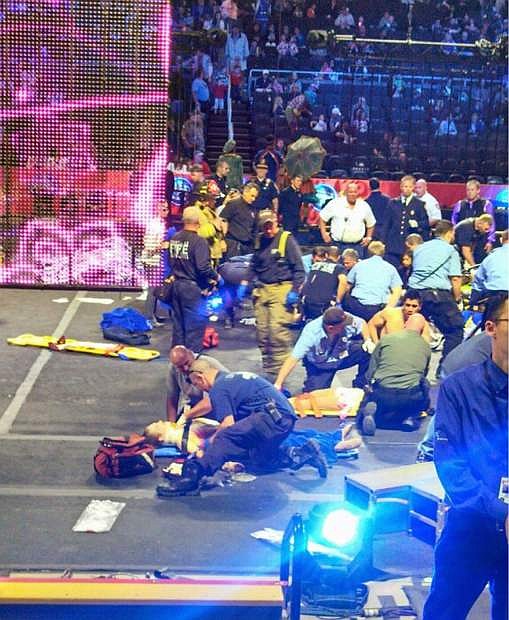 In this photo provided by Rosa Viveiros, first responders work at the center ring after a platform collapsed during an aerial hair-hanging stunt at the Ringling Brothers and Barnum and Bailey Circus, Sunday, May 4, 2014, in Providence, R.I. At least nine performers were seriously injured in the fall, including a dancer below, while an unknown number of others suffered minor injuries. (AP Photo/Rosa Viveiros) MANDATORY CREDIT