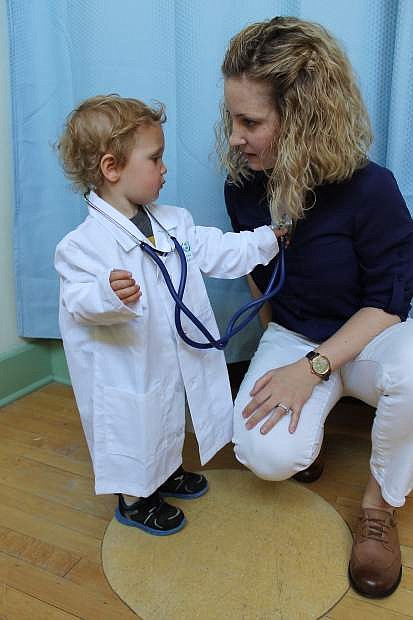 Grayson Denton, 2, plays doctor with his mother, Lauren Denton.