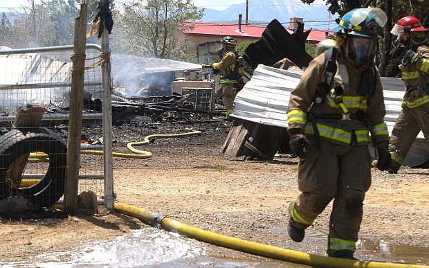 Firefighters extinguish a smoldering structure fire in Moundhouse on Monday.
